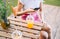 Young woman sitting on a pier lake, on summer day using mobile phone, communicate and drink lemonade