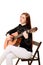 young woman sitting poses in the studio holding a classical guitar