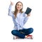 Young woman sitting reading book headphones smartphone