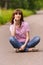 Young woman sitting on road