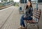 Young woman sitting on a roadside bench