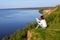 Young woman sitting on the shore of the lake with blank sheet of