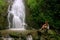 Young woman sitting at Simangande falls on Samosir island, Sumatra, Indonesia