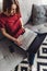 Young woman sitting on sofa with laptop on leap and holding credit card. Online banking, shopping, paying