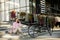 Young woman sitting on the stairs near ebike and usling smartphone