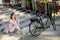 Young woman sitting on the stairs near ebike and usling smartphone