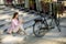 Young woman sitting on the stairs near ebike and usling smartphone