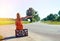 Young woman sitting on suitcase and hitchhiking