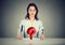 Young woman sitting at table with fork and knife looking at plate with red question mark