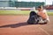 A young woman is sitting on the track and preparing for a training at the stadium. Sport, athletics, athletes