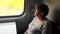 Young woman is sitting in train carriage by window