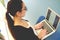 Young woman sitting typing on her laptop