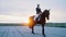 a young woman is sitting upright on a horse and they are on a snowy ranch, and behind them is the sunset