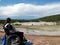 Young woman sitting in wheelchair, observing geysers at Yellowstone National Park