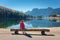 Young woman sitting on the wooden bench near the lake