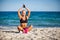 Young woman sitting in yoga pose at the beach