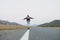 Young woman on skateboard on the road against beautiful mountain landscape, Chuysky tract, Altai