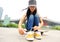 Young woman skateboarder tying shoelace