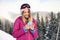 Young woman with ski goggles using smartphone in mountains during vacation