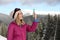 Young woman with ski goggles using smartphone in mountains during winter vacation