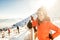 Young woman skier on slopes. Portrait of young woman smiling in skiing equipment, wearing goggles and helmet