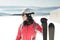 Young woman skier at winter ski resort in mountains, holding skies