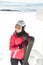 Young woman skier at winter ski resort in mountains, holding skies