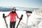 Young woman skier at winter ski resort in mountains, holding skies