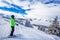 Young woman skiing in Kitzbuehel ski resort and enjouing the beautiful weather with blue sky and Alpine mountains in Austria.