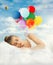 Young woman sleeping in bed. Bright air balloons in blue cloudy sky - sweet dreams