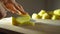 Young woman slicing peeled potato with a knife, slow motion shot