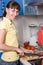 Young woman slicing salad in the kitchen