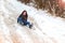 Young woman slipped and fell in the snow road.