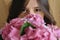 Young woman smelling beautiful hydrangea bouquet on background of  rustic wood. Stylish girl holding pink and purple hydrangea