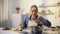 Young woman smelling cooked soup with disgusted face expression, spoiled food