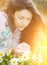 Young woman smelling flowers.