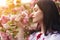 Young woman smelling sakura flowers