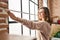 Young woman smiling confident measuring window at new home