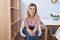 Young woman smiling confident sitting on chair at home