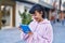 Young woman smiling confident using touchpad at street