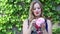 Young Woman Smiling and Eating Pink Cotton Candy With Ivy Background