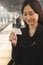 Young Woman Smiling and Looking At Train Ticket on Railroad Platform