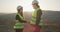 Young woman smiling when shaking hands with male construction worker in overalls. Two engineers shaking hands.
