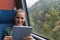 Young woman smiling and using a tablet for studying while travelling by train