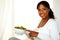 Young woman smiling at you pointing salad