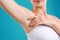 Young woman with smooth clean armpit on background, closeup. Using deodorant