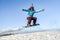 Young woman on the snowboard jumping