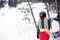 Young woman snowboarder it stands with a snowboard near the ski slopes