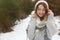 Young woman in snowy conifer forest, space for text. Winter