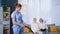 young woman social service worker in a medical uniform helps an elderly couple with cleaning house and cleans floor with